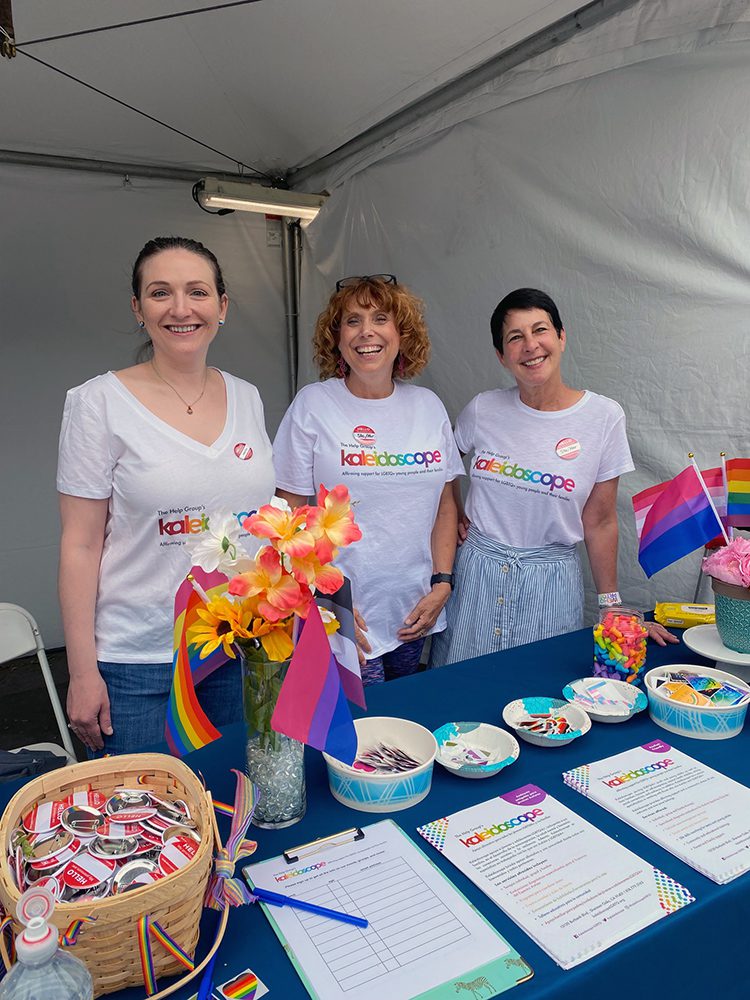 photo of Jeri Rochman and Laurie Stephens standing behind a pride booth